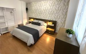 a bedroom with a bed with a black and white blanket at Apartamento turístico Clavero 3 in Plasencia