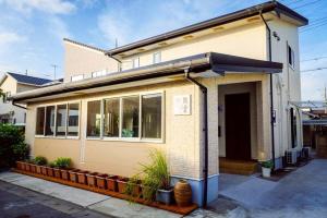 uma casa com muitas janelas numa rua em 空港まで車で15分ビーチまで徒歩1分海沿いの閒雲斎 em Itoman