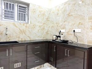 a kitchen with brown cabinets and a counter top at Urban Nest Homestay in Tirupati