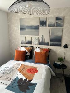Un dormitorio con una cama con almohadas naranjas. en Cosy & Style blue forest room proche CDG AirPort, en Tremblay-en-France