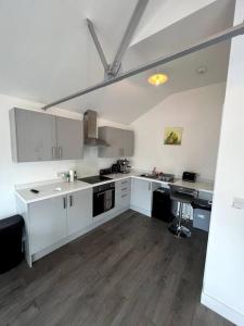 cocina grande con armarios blancos y fregadero en Central Hedon modern apartment -, en Hedon