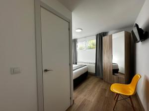 a bedroom with a bed and a yellow chair at Habitacion Monteazul in El Casar de Talamanca +43 photos