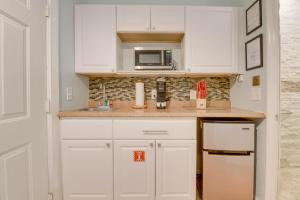a kitchen with white cabinets and a microwave at VanGogh Studio in Key West +8 photos