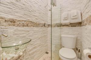 a bathroom with a toilet and a glass shower at VanGogh Studio in Key West