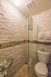 a bathroom with a toilet and a glass shower at VanGogh Studio in Key West