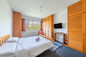a bedroom with a bed and a desk and a television at Lovely 5 Bed House in Barnet , home away from home in New Barnet