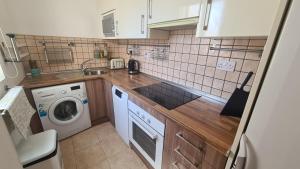 a small kitchen with a washing machine and a washer at Gibraltar Town Centre Flat with Roof Terrace in Gibraltar