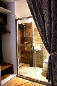 La salle de bains est pourvue d'une douche en verre et de toilettes. dans l'établissement Chambre de la Grande Porte, à Paris