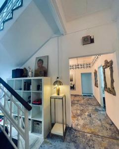 a room with a staircase and a table with a lamp at Yawang homestay in Kota Bharu