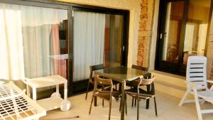 a glass table and chairs on a balcony at Seaside apartment Baja Sardinia - 6pl June July - 150 m from smeraldo beach in Baja Sardinia