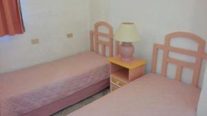 a bedroom with two beds and a lamp on a table at Seaside apartment Baja Sardinia - 6pl June July - 150 m from smeraldo beach in Baja Sardinia