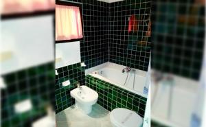 a green tiled bathroom with a toilet and a tub at Seaside apartment Baja Sardinia - 6pl June July - 150 m from smeraldo beach in Baja Sardinia +28 photos