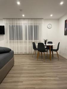 a living room with a table and chairs and a clock at Heimathafen in Offenburg +7 photos