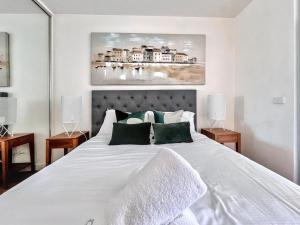 a bedroom with a large white bed with green pillows at Beautiful 1B1B Prahran apartment in Melbourne