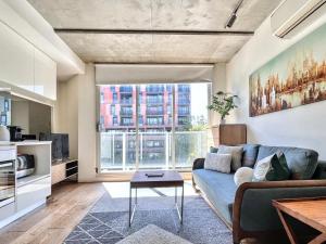 a living room with a couch and a large window at Beautiful 1B1B Prahran apartment in Melbourne