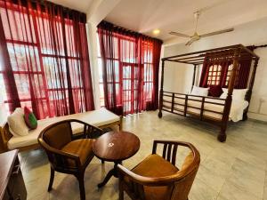 a room with a bed and a table and chairs at Luthmin River View Hotel in Alutgama +34 photos