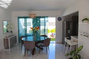 a dining room with a glass table and chairs at Villa Linn bávaro in Punta Cana