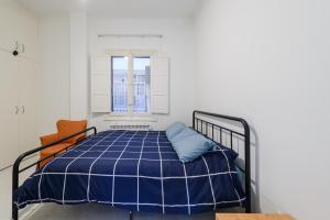 a bedroom with a blue bed with a window at Modern Condo in Goya with Balcony - Retiro park in Madrid