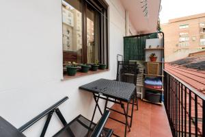 a small balcony with a table and chairs on it at Modern Condo in Goya with Balcony - Retiro park in Madrid