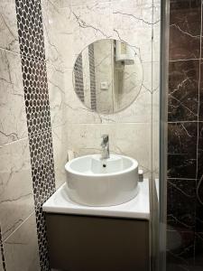 a bathroom with a white sink and a mirror at Торайгырова 89/1 in Pavlodar
