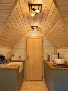 a kitchen with a wooden ceiling and a door at Hatton Lodge in Dunkeld
