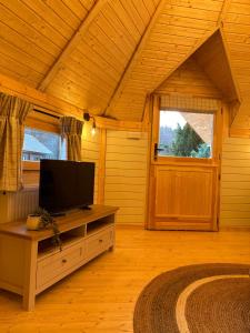 a living room with a tv on a table in a cabin at Hatton Lodge in Dunkeld
