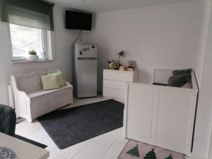 a living room with a refrigerator and a chair at Ferienwohnung Zum Wäldchen in Haiger +3 photos