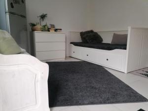 a living room with white furniture and a black rug at Ferienwohnung Zum Wäldchen in Haiger
