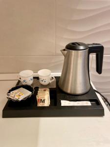 a tea kettle and cups on a black tray at Domus Gaia in Rome