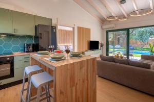 a kitchen and living room with a table and a couch at Galene Eco Luxury Villas in Acharavi