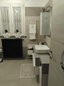 a white bathroom with a sink and a mirror at casavacanze Baggioro in Colle di Compito