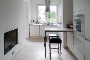 a white kitchen with a table and a television at B&B Glicine in Civitanova Marche