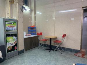 Zimmer mit einer Sodamaschine, einem Tisch und Stühlen in der Unterkunft House ĐDT in Hanoi