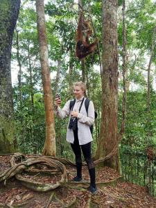 Una donna in piedi nel bosco con una telecamera di Sumatran OrangutanTRAILS a Bukit Lawang Altre 9 foto