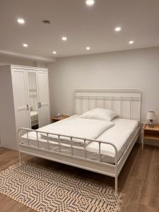a bedroom with a white bed and a rug at Neu! Große Ferienwohnung 3 Zimmer mit Küche und Bad, 90 qm mit Netflix und PS5 in Kaiserslautern