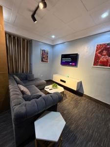 a living room with a couch and a flat screen tv at Big Studio Unit in Lekki phase 1 - Kitchen, Washer, 24-7 light, WiFi & Netflix in Lagos