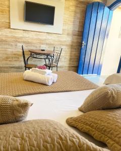 a bedroom with a bed and a table and a tv at Pousada Luz do Sol in Carrancas