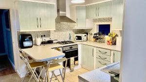 a kitchen with white cabinets and a stove top oven at Serenity in Peterborough