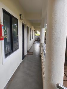 an empty hallway of a house with windows and a sidewalk at Coconut Inn - Parra Goa in Mapusa