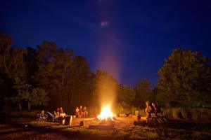 
a crowd of people standing around a fire pit at Avon Tyrrell Outdoor Activity Centre in Bransgore
