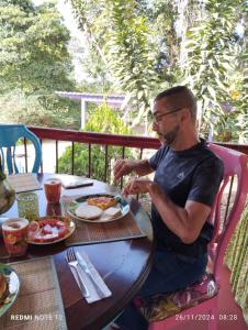 a man sitting at a table with a plate of food at Finca San Miguel Filandia in Filandia