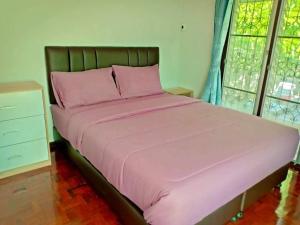 un letto con lenzuola e cuscini rosa in una camera da letto di Nicha Pool Villa by Nichahome a Hua Hin Altre 7 foto