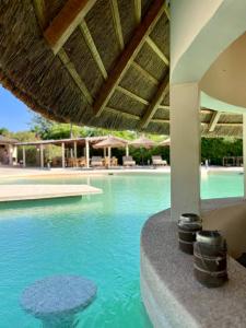 - une piscine d'eau bleue dans un complexe dans l'établissement Nino Lodge, à Samba Dia