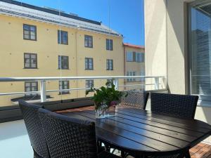 un tavolo e sedie in legno su un balcone con un edificio di Modern apartment with sauna, balcony and parking A17 a Turku
