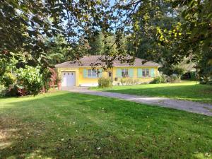 una casa amarilla con una entrada en un patio en Gîte les jardinette 3 personnes, en Futeau