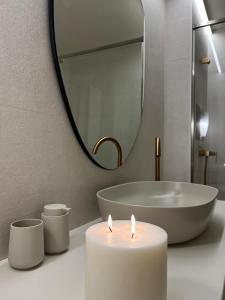 a candle on a bathroom counter with a mirror at Jaén Delice Deluxe & Parking in Jaén +37 photos