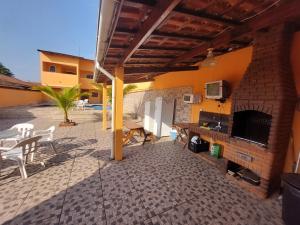 een patio met een open haard en een tafel en stoelen bij Casabelamare Itanhaém in Itanhaém