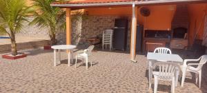 een patio met tafels en stoelen en een keuken bij Casabelamare Itanhaém in Itanhaém