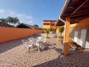 een terras met een tafel en stoelen en een gebouw bij Casabelamare Itanhaém in Itanhaém
