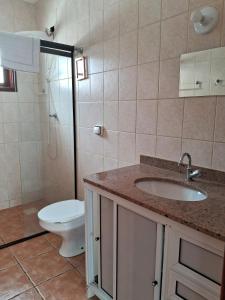 a bathroom with a toilet and a sink and a shower at Casa Rua Salvia, Jd Tulipa in Holambra